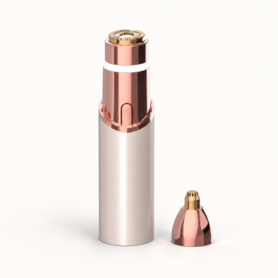 Neluvra 2-in-1 trimmer in champagne Gold, with the round facial head attached and the separate precision head beside it.